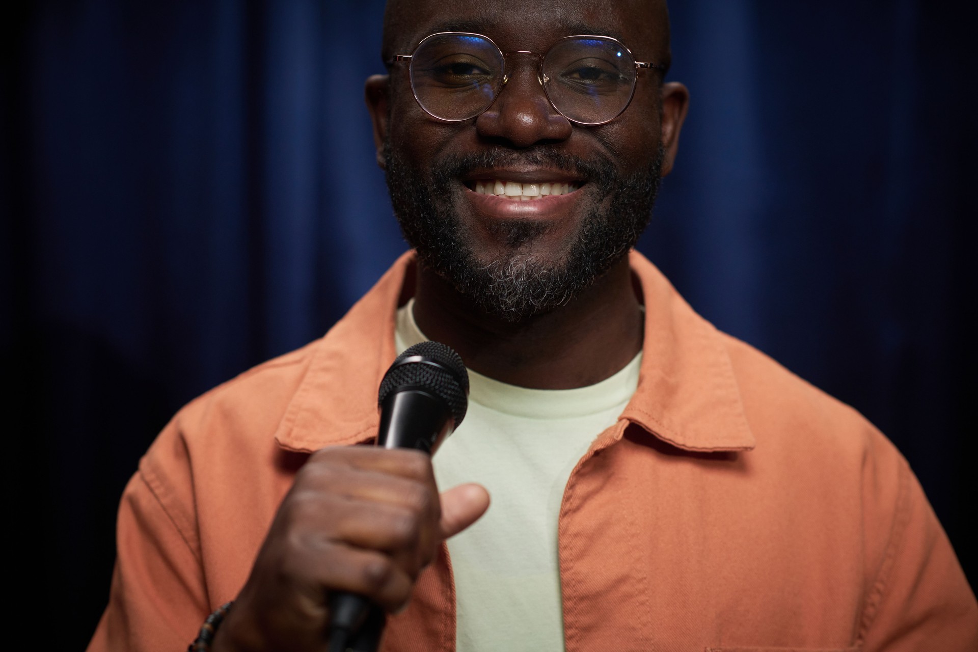 Portrait of Smiling Man Holding Microphone on Stage